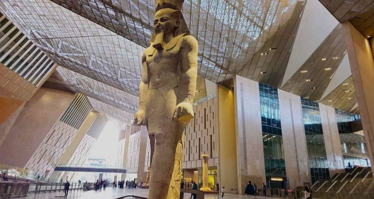 L'immense statue de Ramsès II s'élève majestueusement dans l'atrium du Grand Musée égyptien moderne, coiffé d'une toiture en verre.