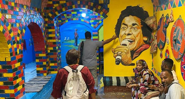 Mural colorido con personas interactuando en un espacio pequeño.