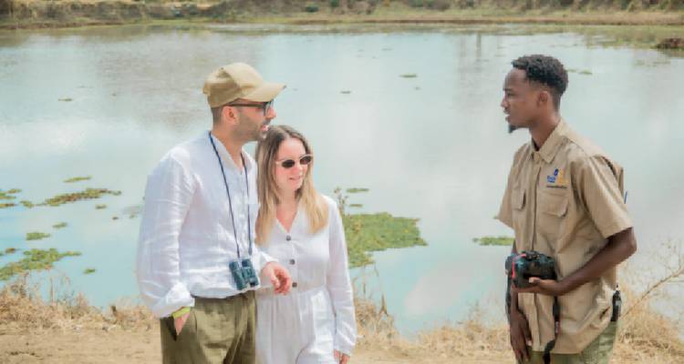 A group of people talking near a water body.
