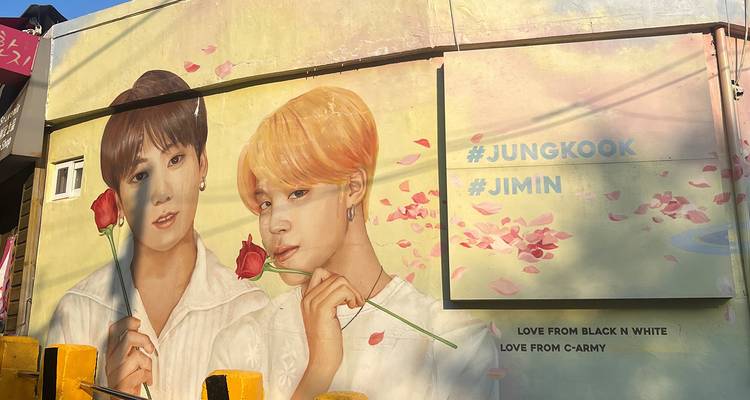 Mural colorido de dos personalidades famosas con rosas.