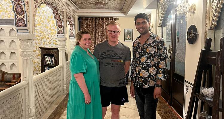 Drie mensen die binnenshuis staan en glimlachen voor de camera.