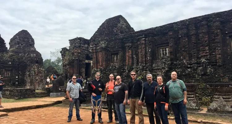 Des touristes qui prennent la pose devant des ruines antiques.