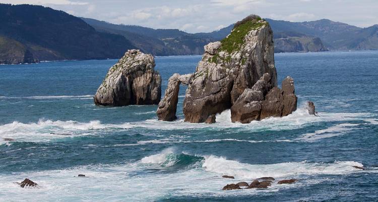 Espectaculares farallones marinos y olas del Atlántico que rompen contra una costa escarpada.