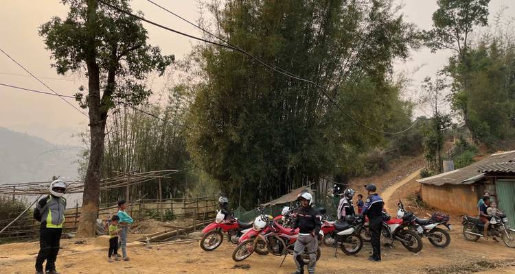 Motorcyclists gathered in a rustic rural area.