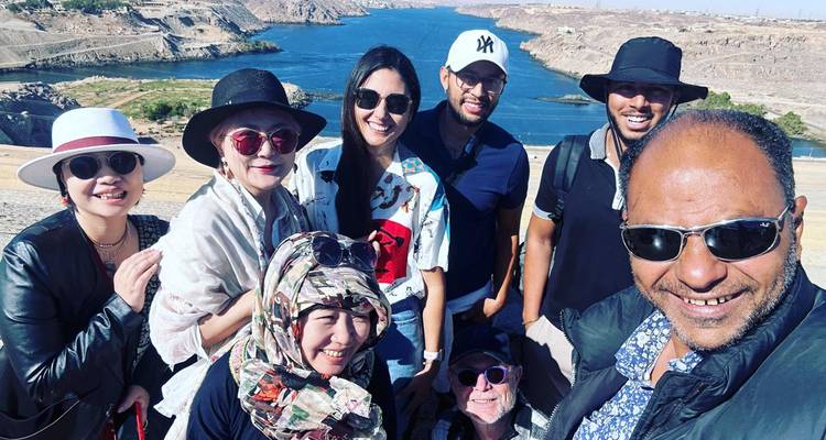 Selfie grupal sonriente con vista al Nilo y el paisaje desértico cerca de la Presa Alta de Asuán.