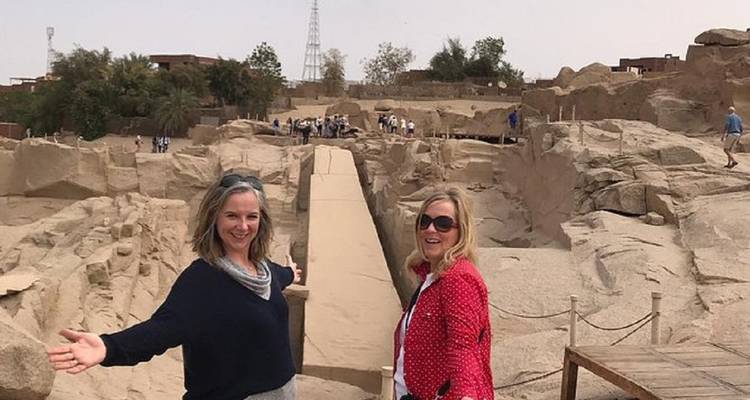 Dos mujeres de pie en la cantera del Obelisco Inacabado sonriendo hacia la cámara.