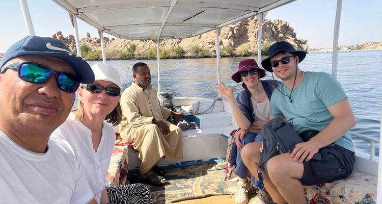 Viajeros y barquero local sentados dentro de una pequeña lancha motora en el Nilo.