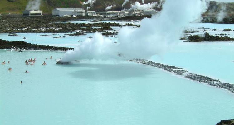Blue Lagoon’s milky geothermal waters with bathers and steam vents against a volcanic backdrop.