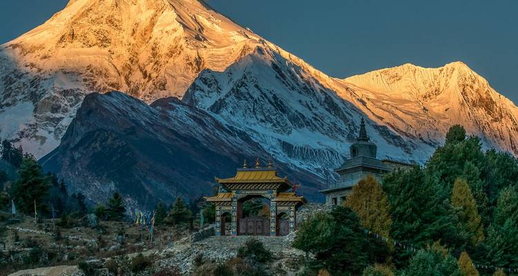 Golden mountain landscape with pagoda at sunset.