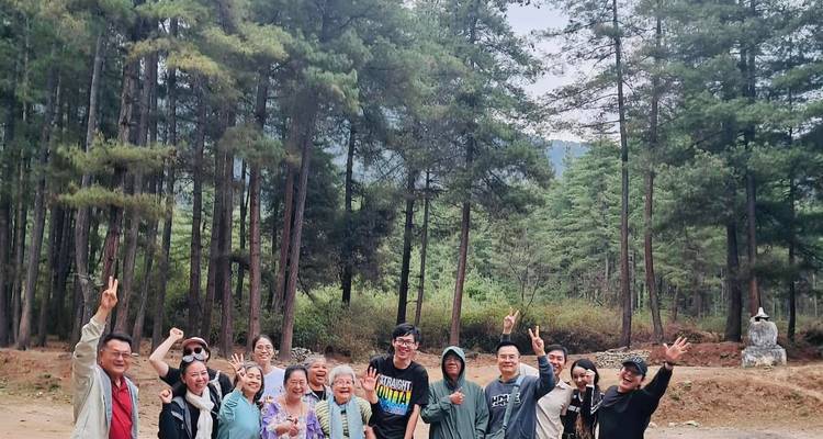 Groupe de personnes posant joyeusement dans un cadre forestier.