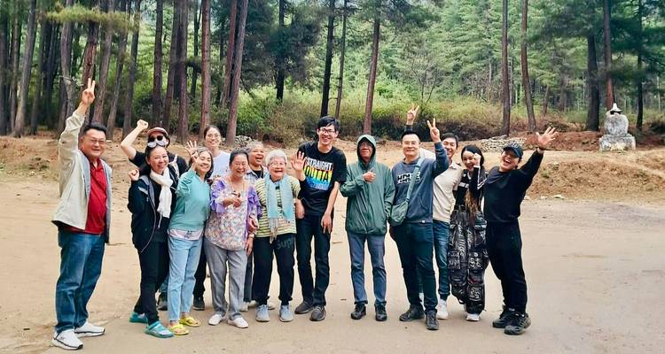 Groupe de personnes posant joyeusement dans un environnement forestier.