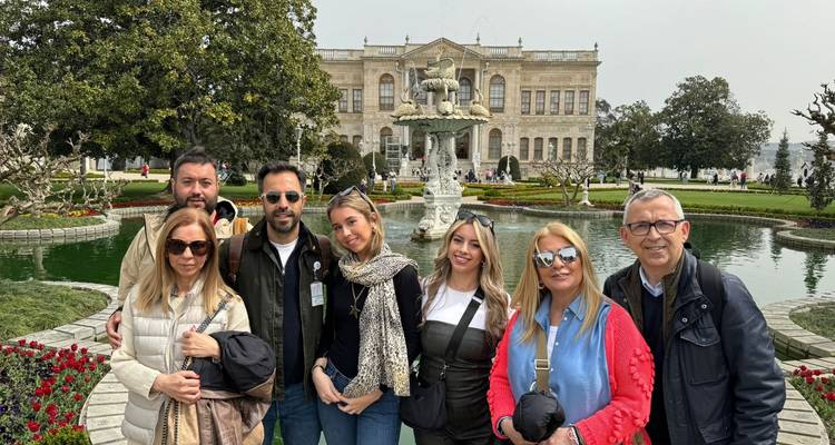 Grupo de personas posando frente al Palacio de Dolmabahçe en Estambul.