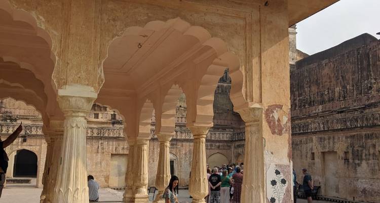 Intérieur d'un bâtiment historique avec des arches et des touristes.