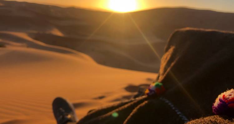 Schilderachtig woestijnlandschap tijdens zonsondergang, met zachte lensflare.