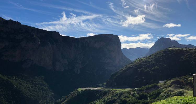 Ruige berglandschap onder een hemel met verspreide wolken.