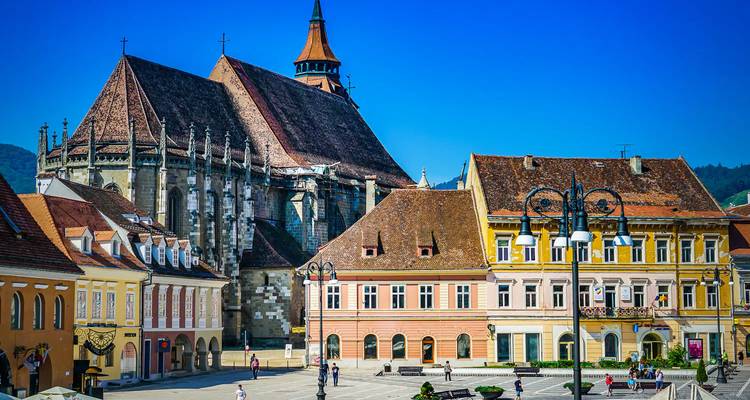 Historisch stadsplein met kleurrijke gebouwen en een kerk.