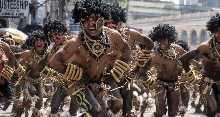 Gruppe von Menschen in traditionellen Kostümen, die an einem Straßenfest teilnehmen