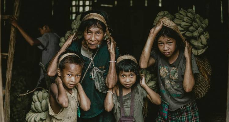 Familie trägt Bananen in ein Haus hinein