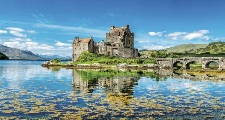 Ein malerischer Blick auf Eilean Donan Castle mit Spiegelungen im Wasser.