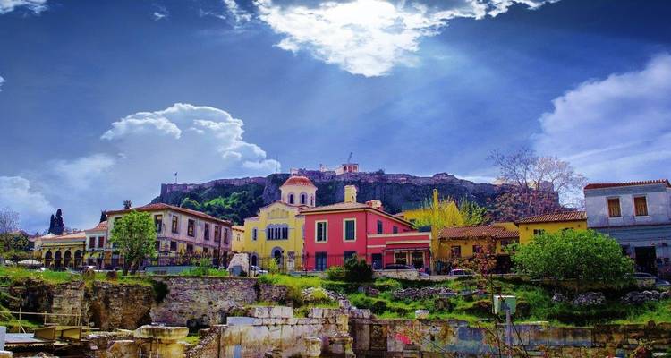 Maisons colorées sous des nuages dramatiques avec des ruines anciennes.