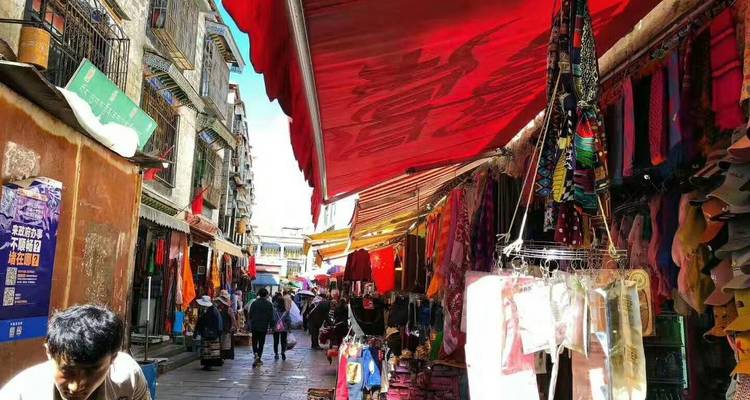 A bustling street market with colorful fabric stalls and shoppers.