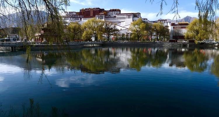 A serene setting with a palace reflecting in a lake.