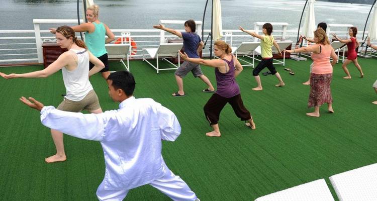 Des personnes pratiquant le Tai Chi sur le pont d'un bateau.