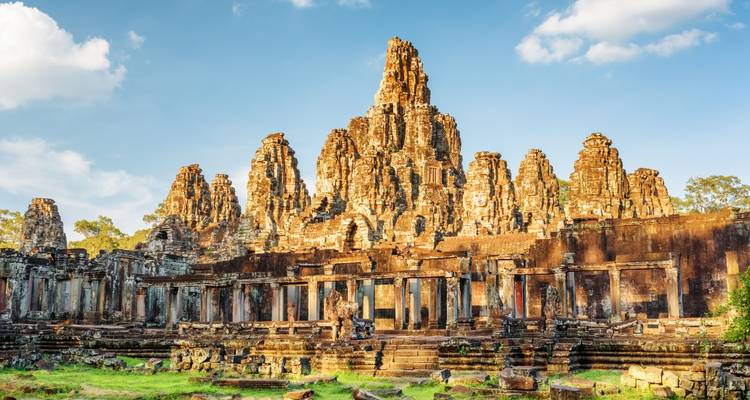 Gouden stenen torens van de Bayon Tempel met sereen uitgehouwen gezichten verlicht door warm zonlicht