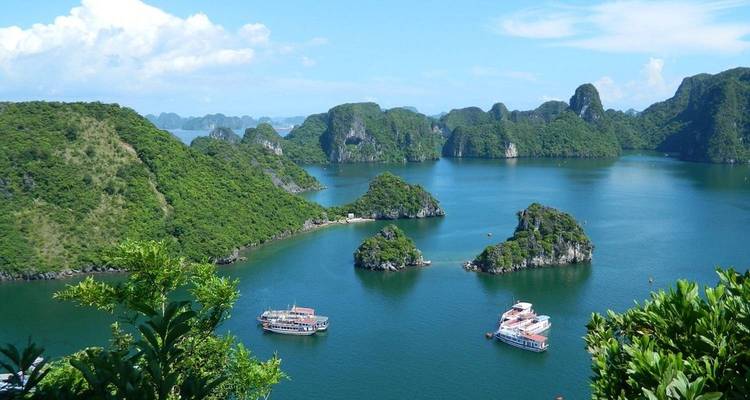 Boten die varen in Halong Bay met kalkstenen eilanden.