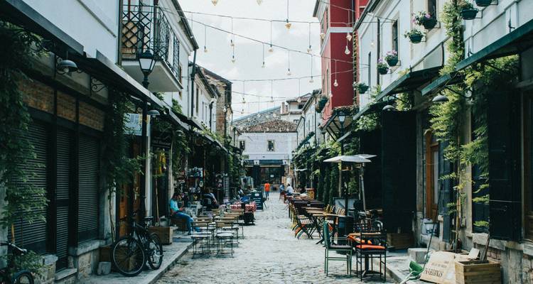 Rue de vieille ville avec cafés et terrasses.
