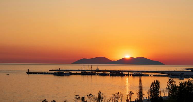 Coucher de soleil sur la mer avec silhouettes d'îles.