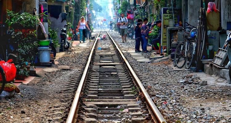 Bahngleis durch einen lebhaften Straßenmarkt.