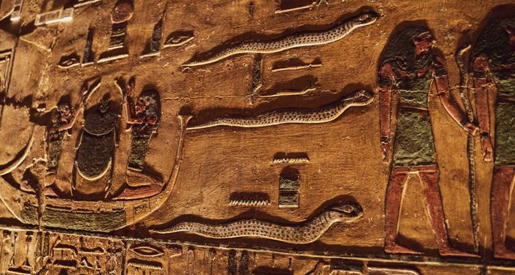 Oude Egyptische hiërogliefen en gravures op een muur.