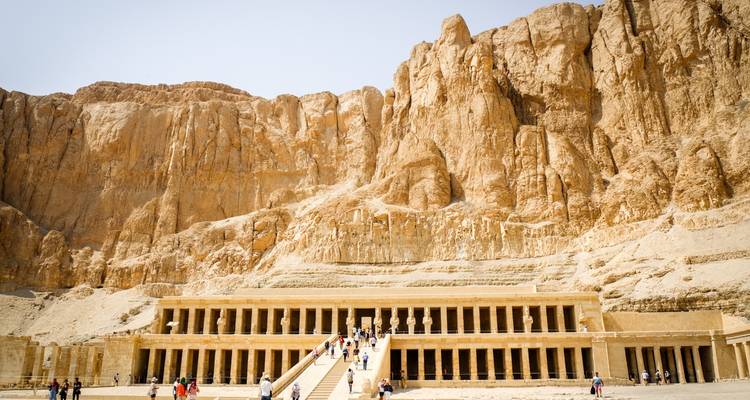 Grote Egyptische tempel met zuilen en toeristen.