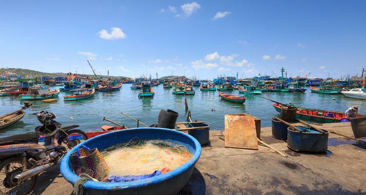 Port de pêche animé avec de nombreux bateaux colorés et du matériel de pêche.