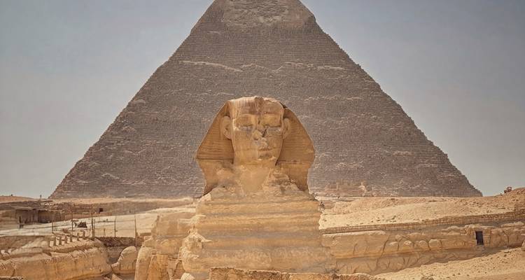 Le Sphinx avec une pyramide en arrière-plan sous un ciel brumeux.