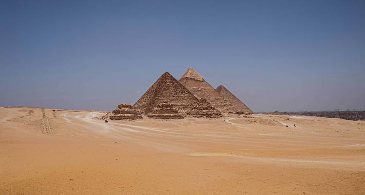 Les Pyramides de Gizeh dans le désert sous un ciel bleu dégagé.