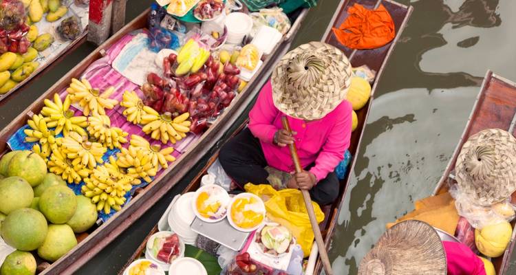Drijvende markt met kleurrijke vruchten en mensen in boten.