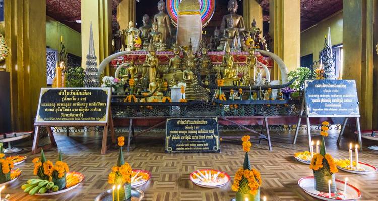 Interieur van een boeddhistische tempel met offers en versieringen.