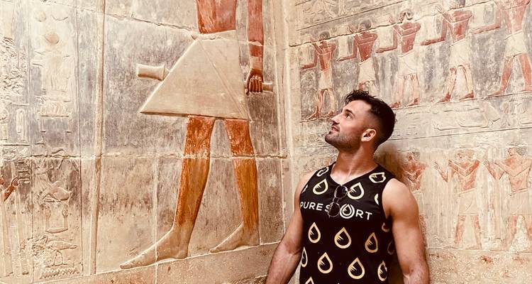 Man die naar oude Egyptische muursculpturen kijkt.