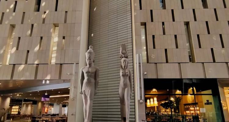 Moderne gebouwinterieur met grote Egyptische beelden.