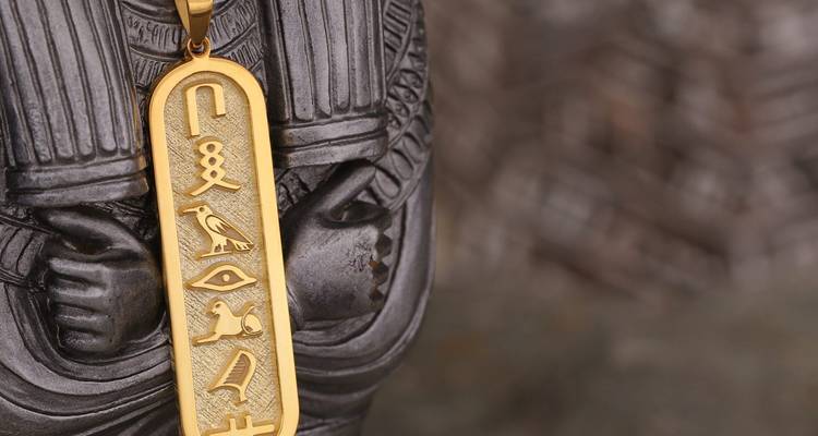 Nahaufnahme eines goldenen ägyptischen Hieroglyphen-Anhängers.