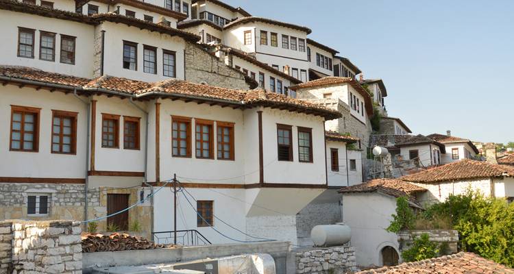Traditionele stenen gebouwen met houten balkons in een bergachtig gebied.