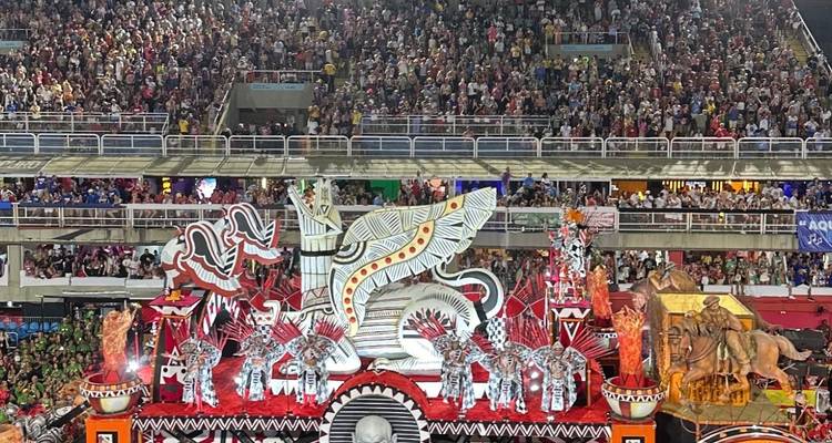 Des chars élaborés et des artistes dans un défilé de carnaval nocturne.