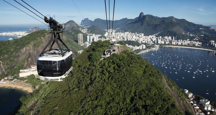 Vue aérienne de Rio de Janeiro avec téléphériques et montagnes luxuriantes.