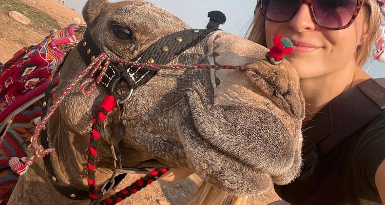 Close-up selfie with a camel, showing colorful adornments.