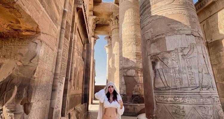 Person posing among ancient Egyptian temple ruins.