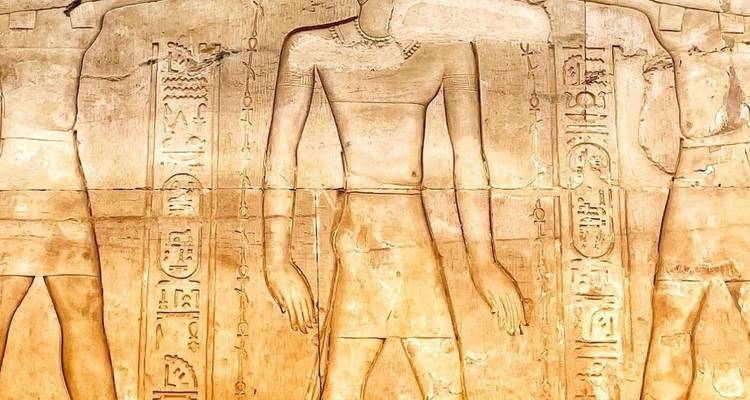 Close-up of detailed hieroglyphs and carvings on a stone wall.