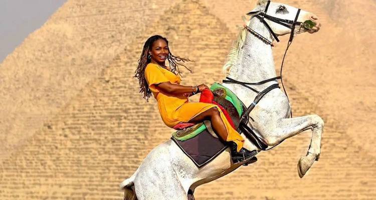 Woman riding a horse in front of the Great Pyramid, Cairo.