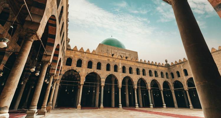 Binnenplaats van een moskee met bogen en een koepel.